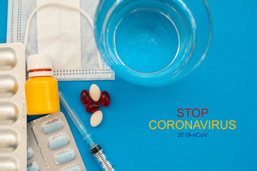 The inscription Stop Coronavirus on blue background with medical flat lay