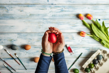 Woman holding coloring Easter egg in her hands
