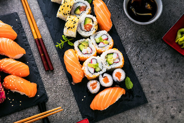 apanese sushi food. Maki ands rolls with tuna, salmon, shrimp, crab and avocado. Top view of assorted sushi. Rainbow sushi roll, uramaki, hosomaki and nigiri