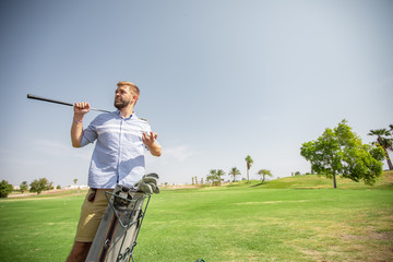 A man on a golf course examines the equipment and prepares for a sporting event at the golf club.