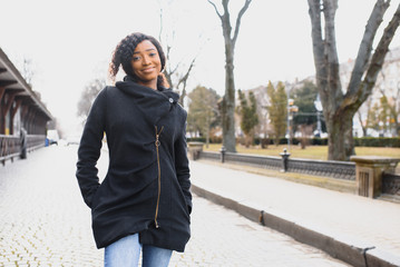 Obraz premium Outdoor close up portrait of young cute happy smiling african american woman with afro hairstyle.