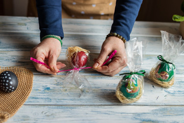 Woman wrapping gift for Easter holiday celebration