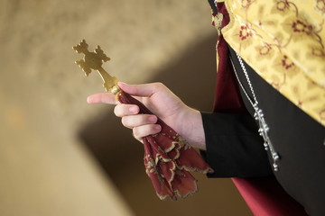 cross in the hand of a priest