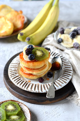 Fritters with honey, banana, blueberries and kiwi, breakfast