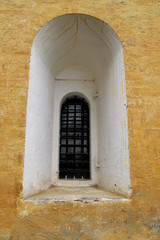 Window in old yellow building, church or monastery. Russian or European architecture