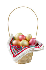 Golden, bronze and pink Easter eggs in basket isolated on white background.