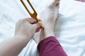 Hand holding a tuning fork and crystal stone  .