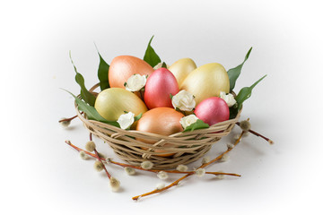 Golden, bronze and pink Easter eggs with pussy willow in basket.