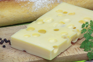 tranche d'emmental et baguette de pain sur une table