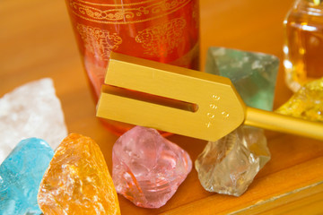 Hand holding a tuning fork and crystal stone  .