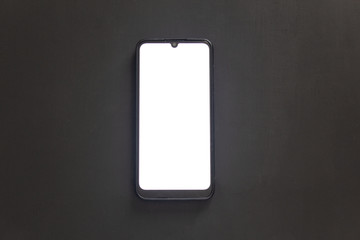 A black smartphone with a white display and a teardrop-shaped cutout lies on a dark isolated background.