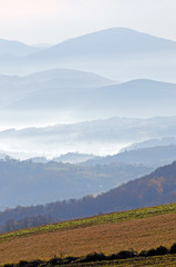  Distant hills in the haze. Beautiful mountain scenery. Mystical rural scenes. Scattered houses of mountain villages. Beautiful nature background.