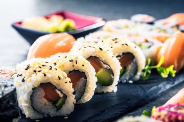 Fotobehang apanese sushi eten. Maki ands rolls met tonijn, zalm, garnalen, krab en avocado. Bovenaanzicht van diverse sushi. Rainbow sushi roll, uramaki, hosomaki en nigiri © karepa