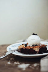Homemade blueberry pie with vanilla ice cream on wooden background - 329300424