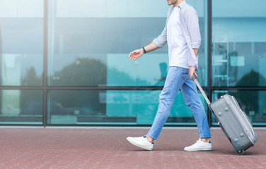 Going to terminal. Unrecognizable guy walking to airport with luggage