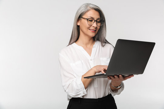 Image of adult mature woman wearing office clothes using laptop computer