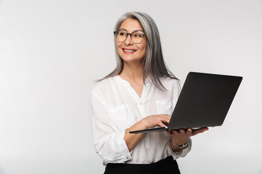 Image of adult mature woman wearing office clothes using laptop computer
