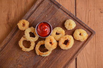 Golden crispy onion rings coated with breadcrumbs and deep fried. Fast food, junk food concept.