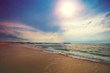 Seascape in the evening. Sunset on the beach. Sandy seashore with beautuful sky