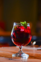 Classic alcoholic summer cocktail with lemon and mint garnish on a bar table.