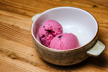 Ice cream in bowl on a wooden table.