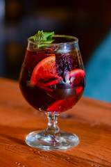 Classic alcoholic summer cocktail with lemon and mint garnish on a bar table.