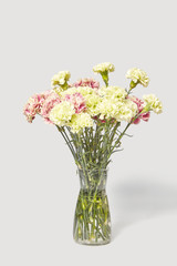 Glass vase with bouquet from fresh beautiful carnation flowers.