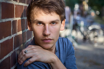 Casually dressed young man looking seriously and determined into the camera.