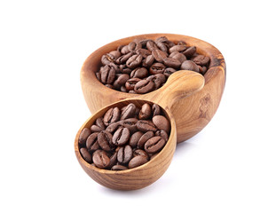 Coffee beans in a wooden spoon on white background.