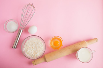 Fototapeta na wymiar Frame of food ingredients for baking on a gently pink pastel background. Cooking flat lay with copy space. Top view. Baking concept.