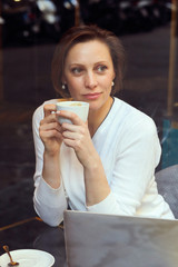 Business woman sitting in a restaurant with a laptop and coffee.