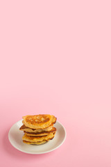 Pancakes with berries on a bright pastel background, copy space.