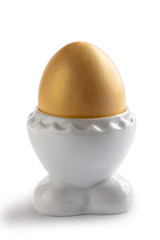 Golden egg in white stand isolated on white background.  Happy Easter.