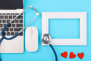 Doctor's Day concept, flat lay top view, stethoscope with laptop computer and photo frame diagnosis of heart disease