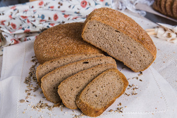 Whole- grain rye bread on a tree with wheat grains. Dietary product of proper nutrition