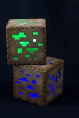 Fototapeten Minecraft Würfel aus Kunststoff. Zwei braune Minecraft-Würfel mit leuchtenden Fenstern © SVETLANA
