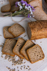 Whole- grain rye bread on a tree with wheat grains. Dietary product of proper nutrition