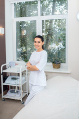 Famous plastic surgeon standing near window in her spacious room