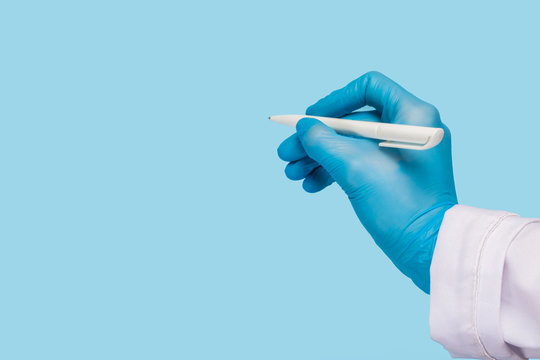 A Female Hand In A Medical Glove And In A White Coat Holds A Pen And Writes In The Air On A Blue Background. Mock Up