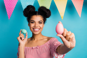 Photo of pretty dark skin lady hold holiday painted eggs colorful decor flags good mood family meeting dinner wear red white striped shirt naked shoulders isolated blue color background
