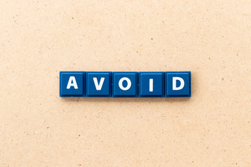 Tile letter in word avoid on wood background