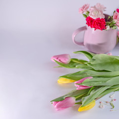 Bouquet of yellow and pink tulips on white background. Cup with flowers. Valentine's Day and Mother's Day background.