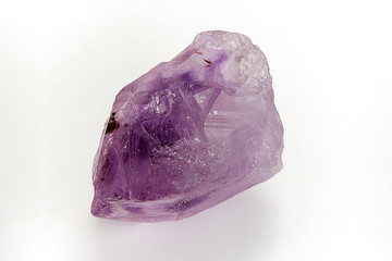 Natural raw mineral crystal amethyst violet close-up isolated on white background