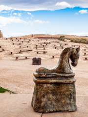 Caballo de ajedrez en gran tamaño en el castillo de Lorca con bancos al fondo