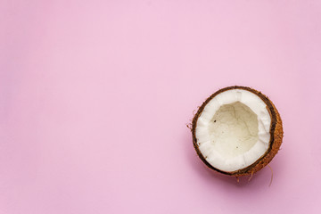 Ripe coconut cut on two half isolated on pink background