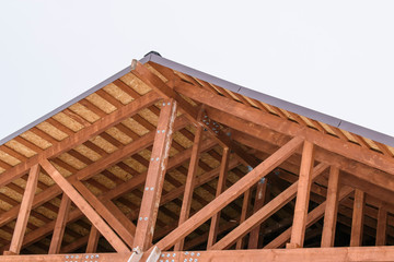 System of a pitched roof without a crossbar. Vertical rack, inclined struts, rafters and lathing. Low-rise construction concept. 