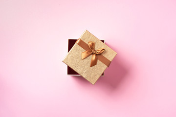 Valentine's Day. Golden gift box on pink background. Top view. Copy space. Festive backdrop for holidays: Birthday, Valentines day, Christmas, New Year. Flat lay style. Banner