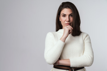 Brunette woman in white sweater posing isolated.