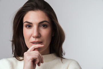 Brunette woman in white sweater posing isolated.