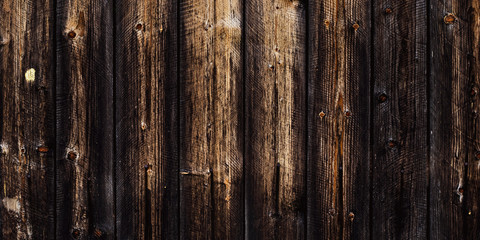 Rustic old wood background, dark wooden texture, wide panoramic banner. Natural weathered fence with nails. Brown planks timber floor.